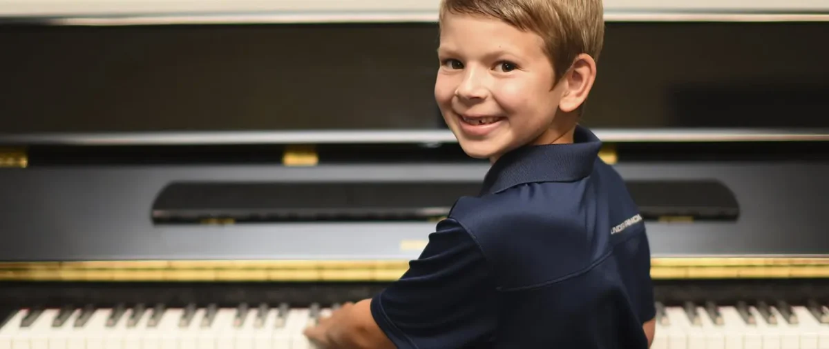 Student playing piano at a piano lesson