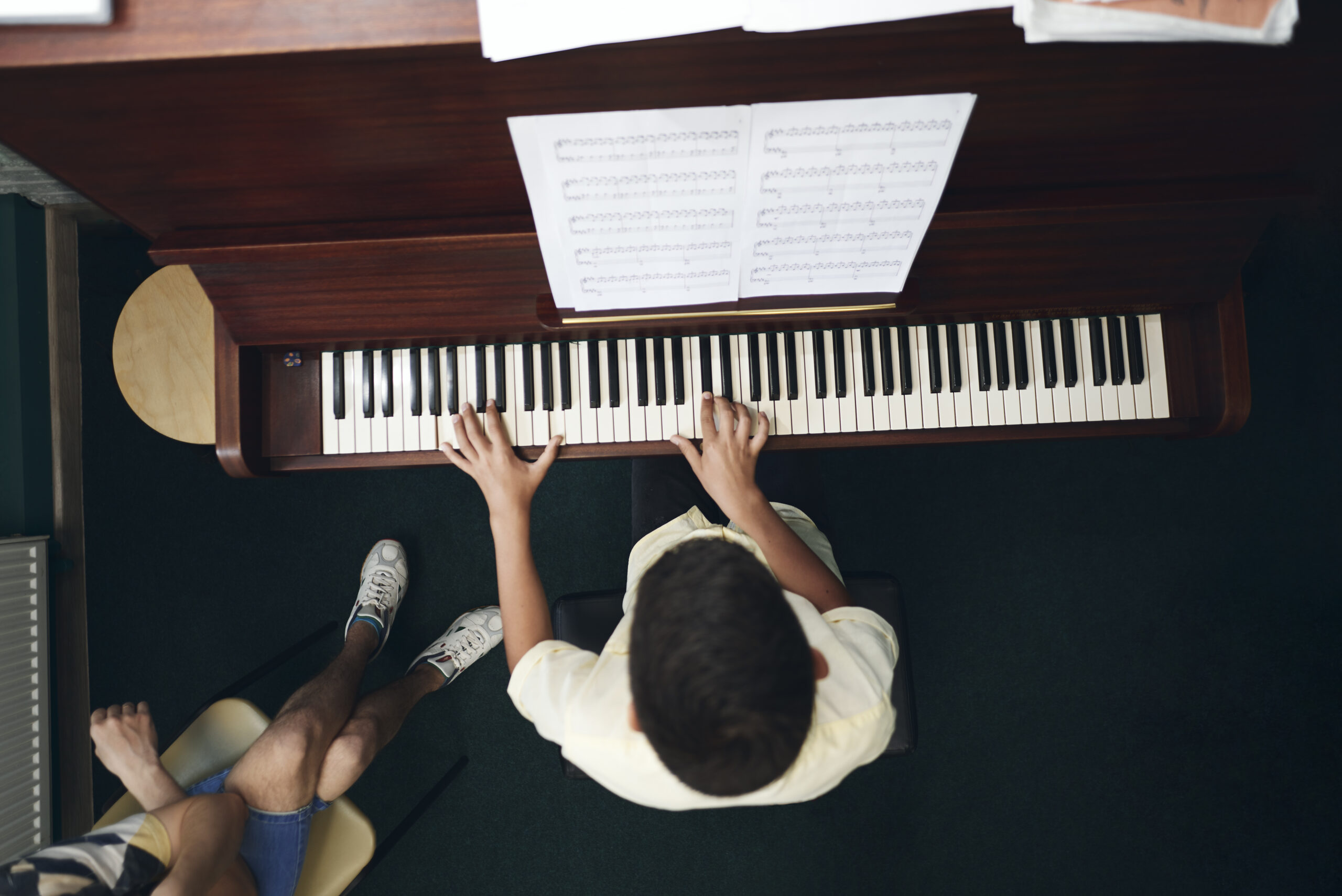 Student playing piano at a lesson
